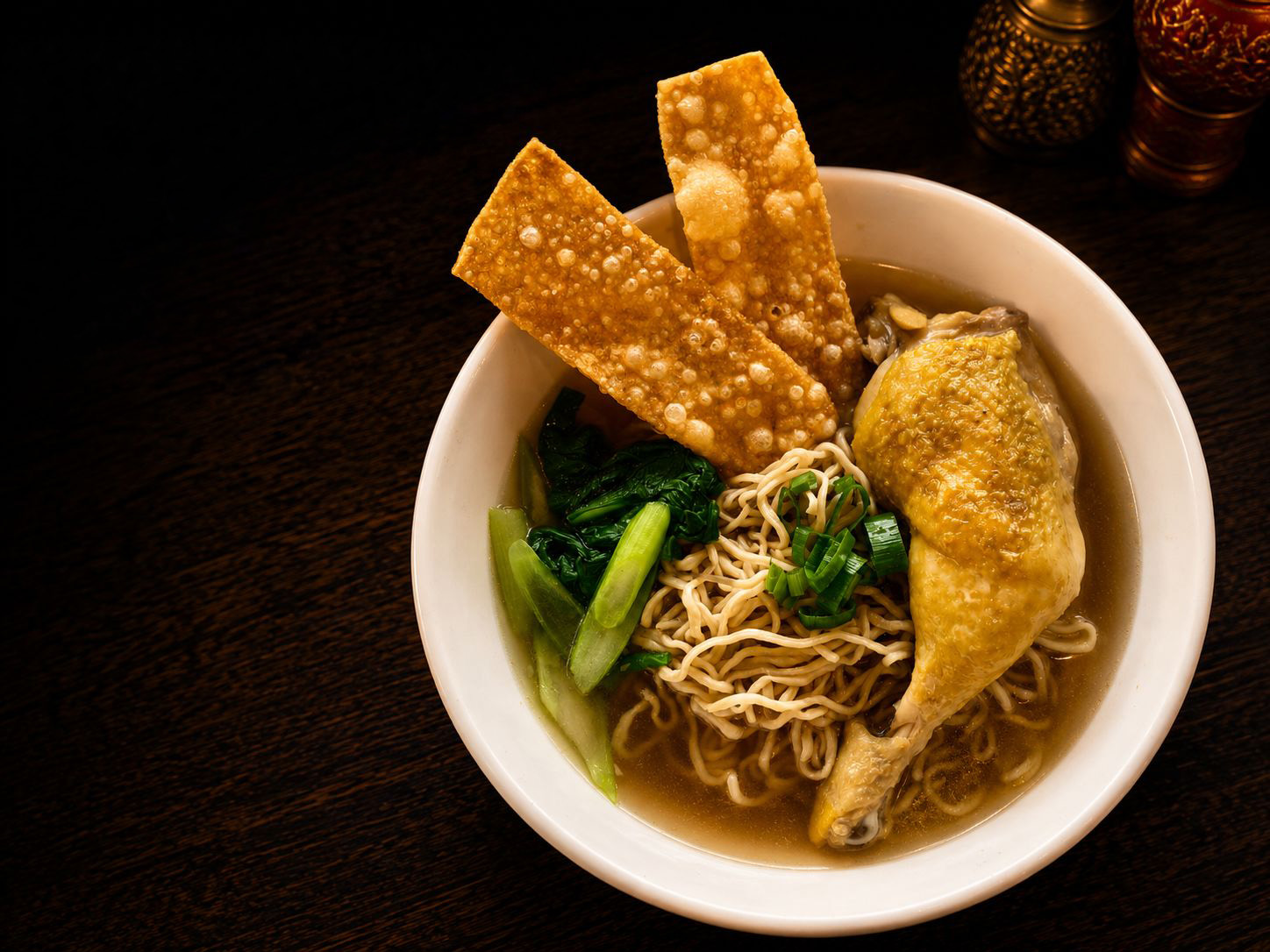 Soupe de nouilles au poulet avec cuisse dorée, bok choy et galettes croustillantes